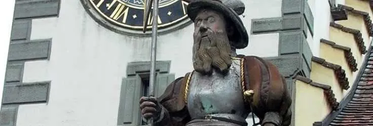 Historic clock and statue in a Swiss town