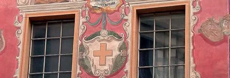 Painted historic Swiss house facade with shuttered windows